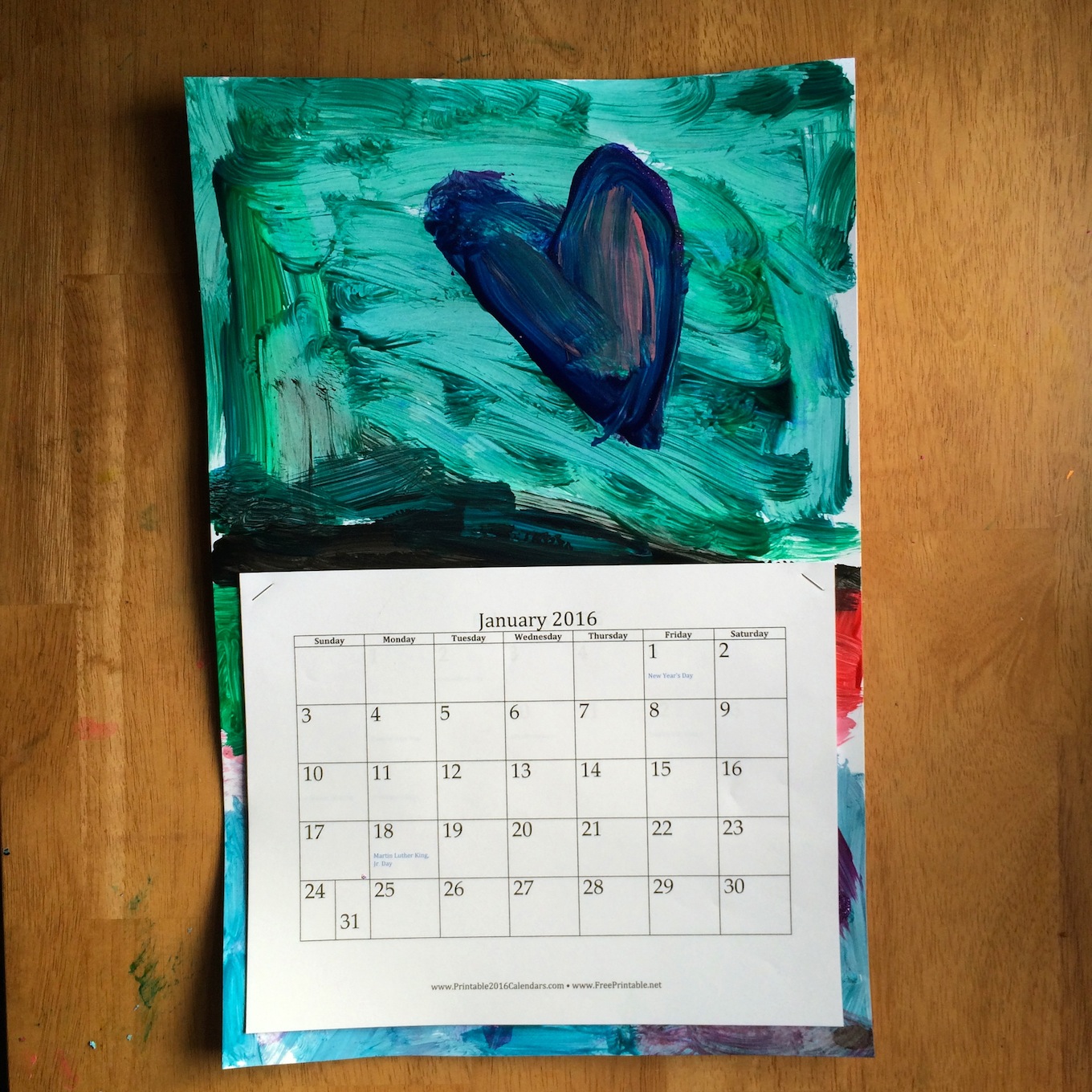 DIY Kid's Art Calender - This activity is easy peasy lemon squeezy! Find some kid art, staple a printable calendar to it, and that's it!