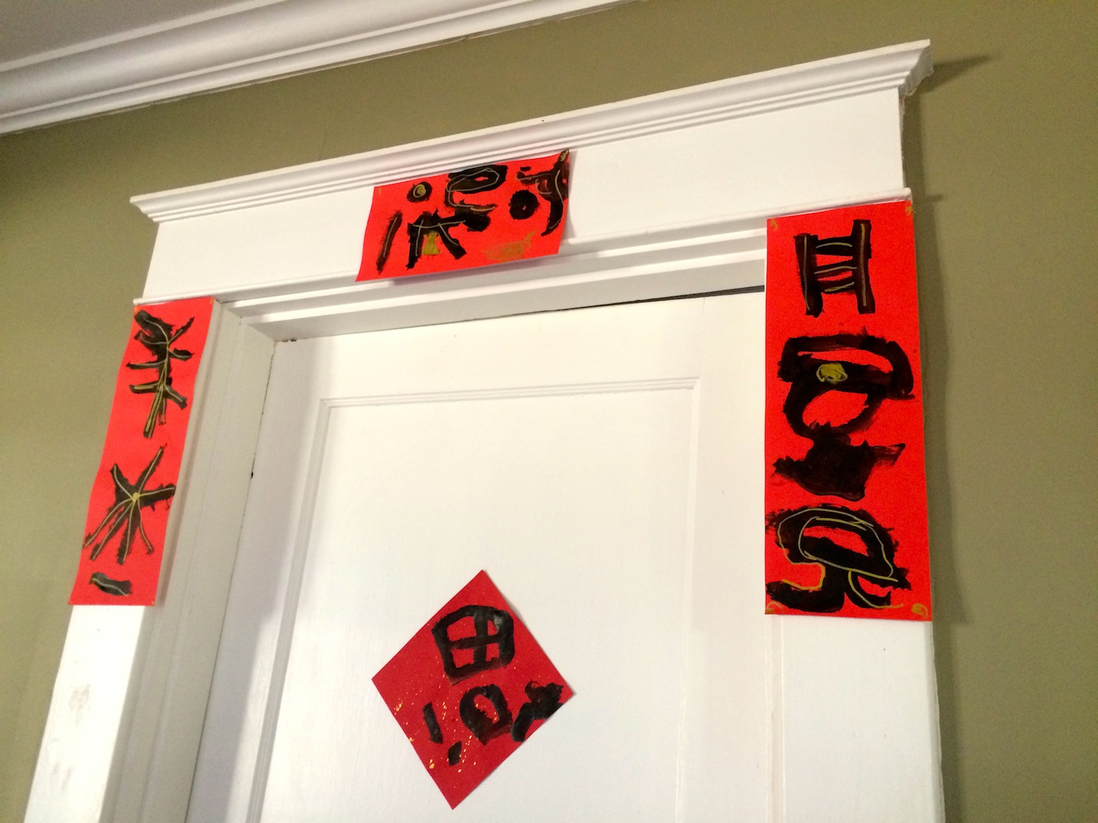 Hanging goodluck characters and spring couplet artwork over doorframe in celebration of Chinese New Year