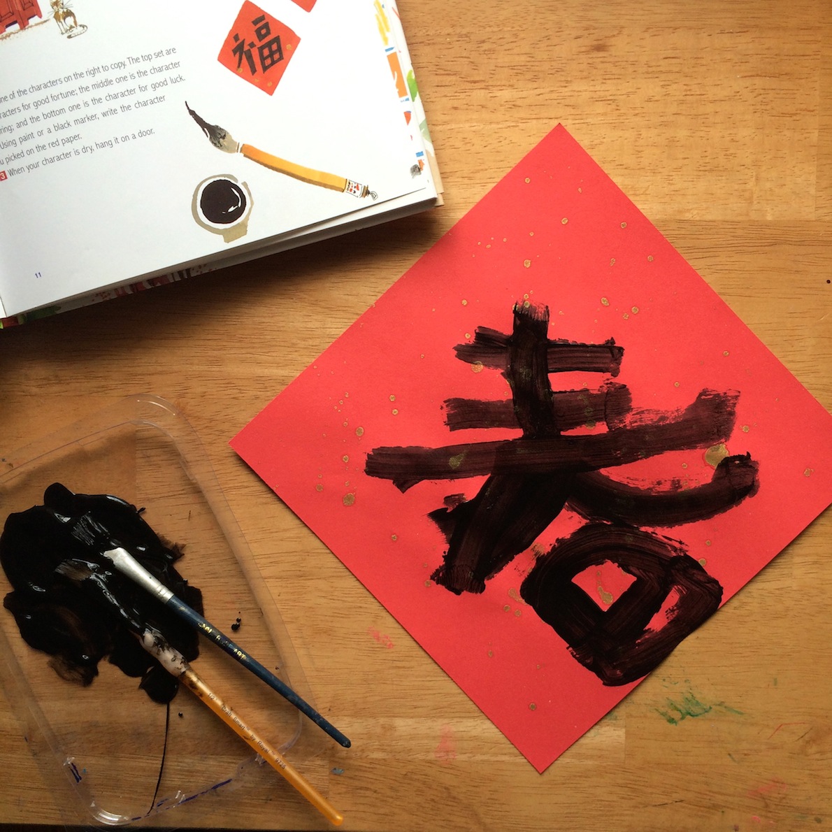 Spring character painted on gold flecked paper for the Chinese Lunar New Year